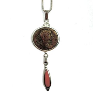 Colgante moneda romana con coral rojo hecho por Carlos Tellechea en Sóller, Mallorca